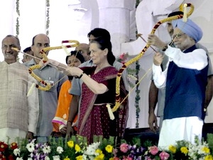 Thủ tướng Manmohan Singh và bà Sonia Gandhi cầm cung bắn tên vào hình nộm quỷ Ravana tại lễ hội (Nguồn: thehindu.com)